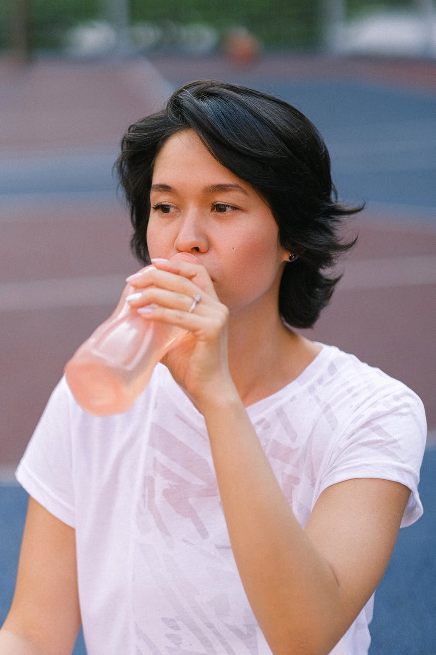 lady sitting on court with bottle of water